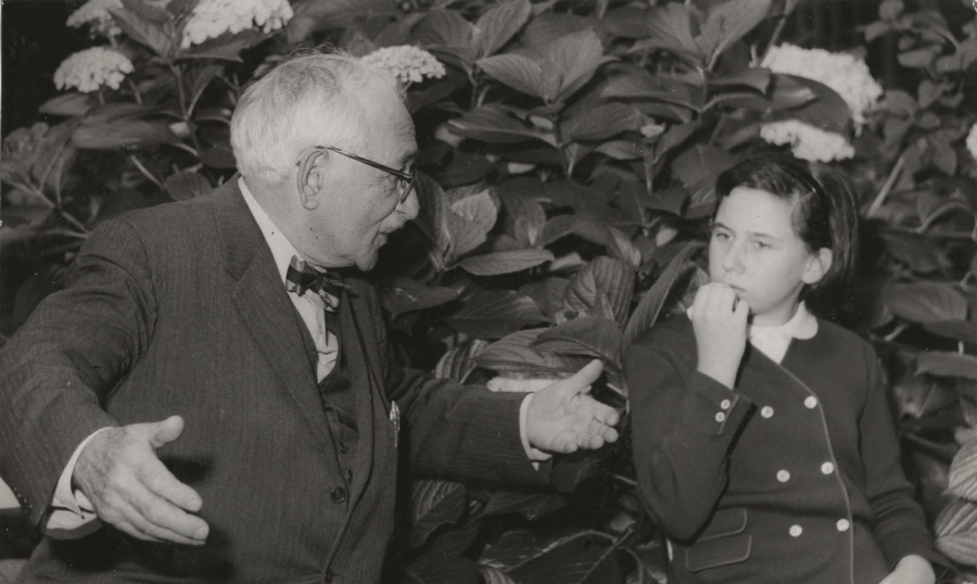 Black and white vintage photo of grandfather talking to granddaughter